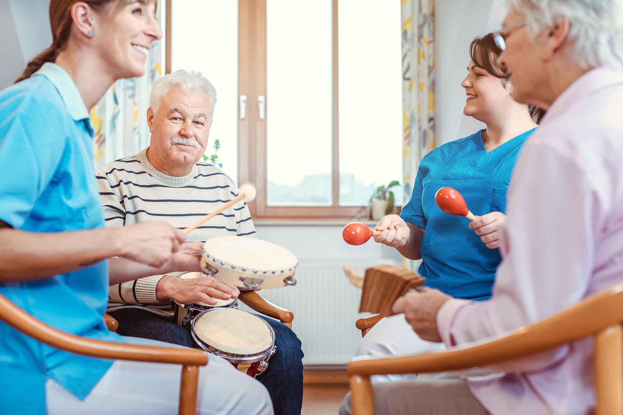Elderly patients playing music with healthcare professionals