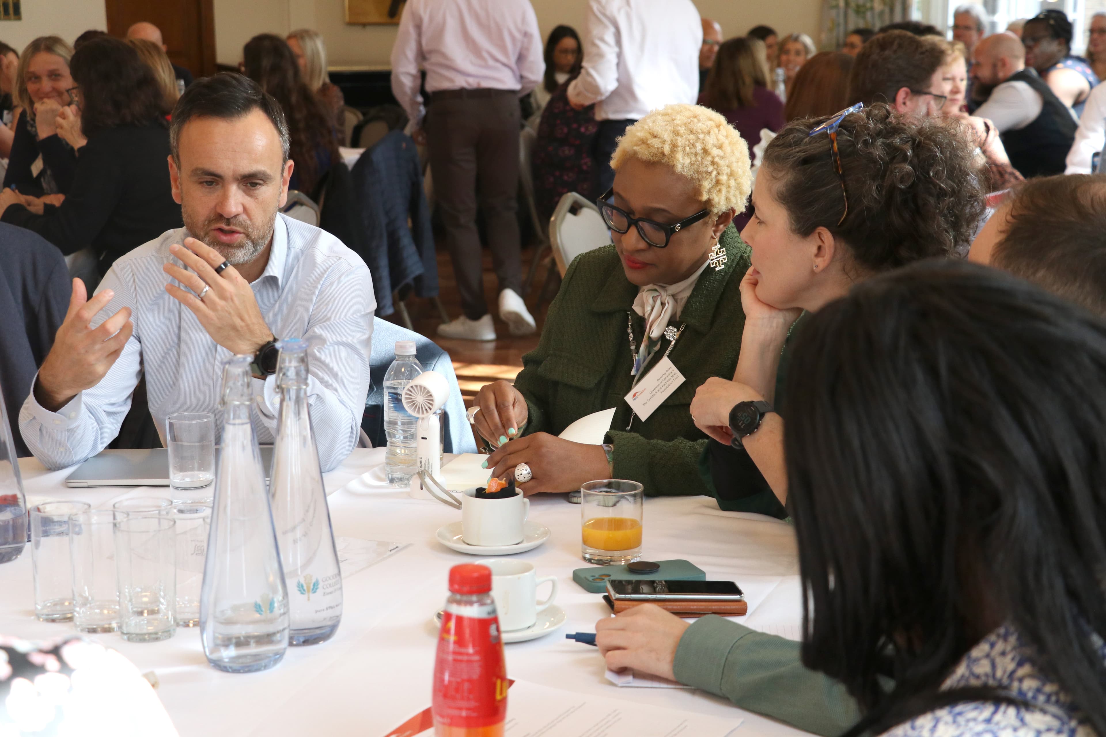A group of NHS leaders engaged in discussion around a table at a one of our networks. 